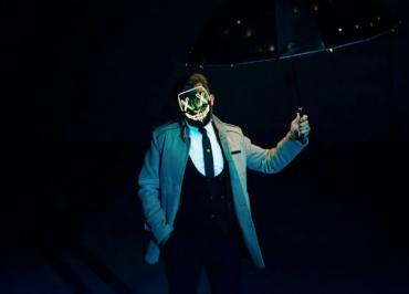 a man in a suit and mask holding an umbrella