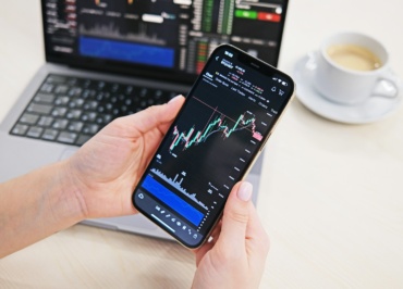 a person holding a cell phone in front of a laptop