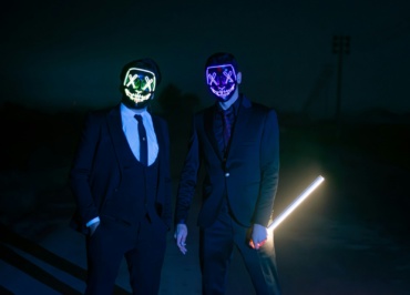 two men in suits and masks standing next to each other