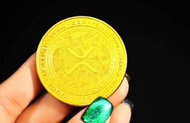 gold round coin on persons hand
