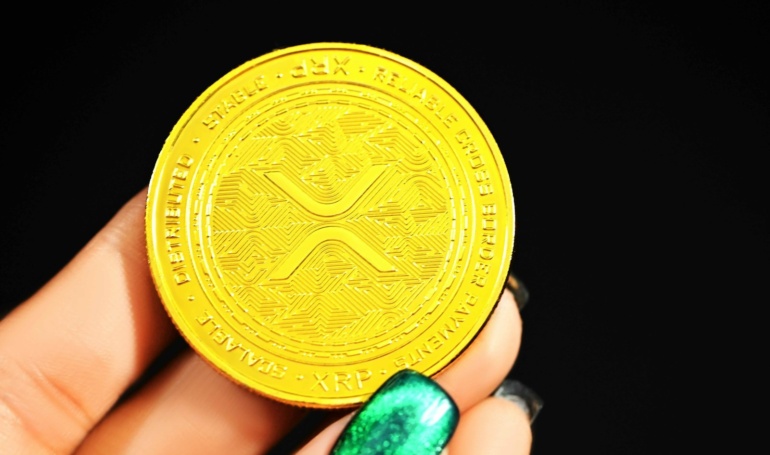 gold round coin on persons hand