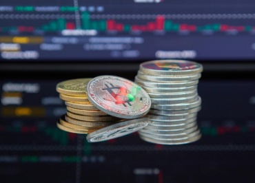 Close-up of cryptocurrency coins with a market graph background.
