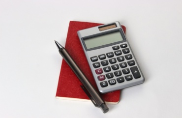 black and silver calculator beside black pen