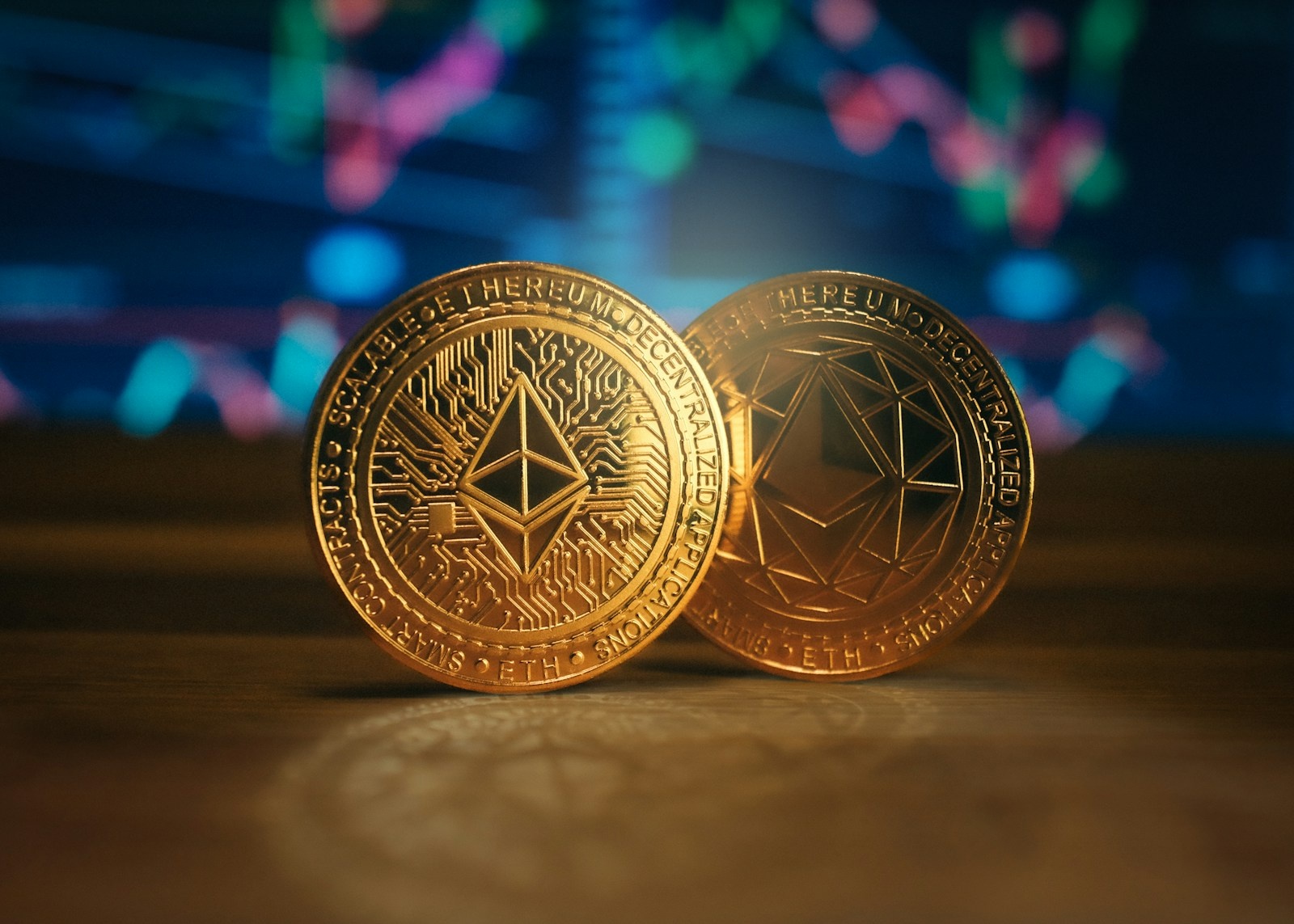 two gold coin sitting on top of a wooden table