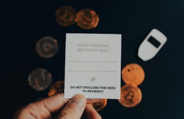 a person holding a business card in front of a pile of coins