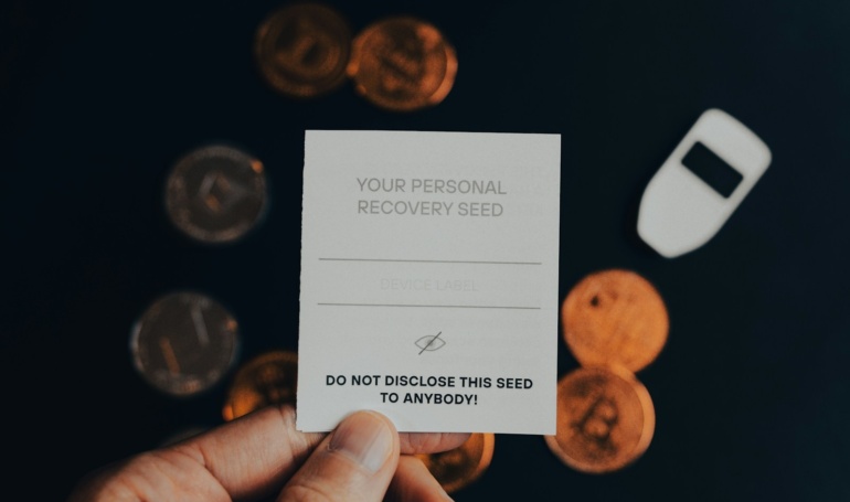 a person holding a business card in front of a pile of coins